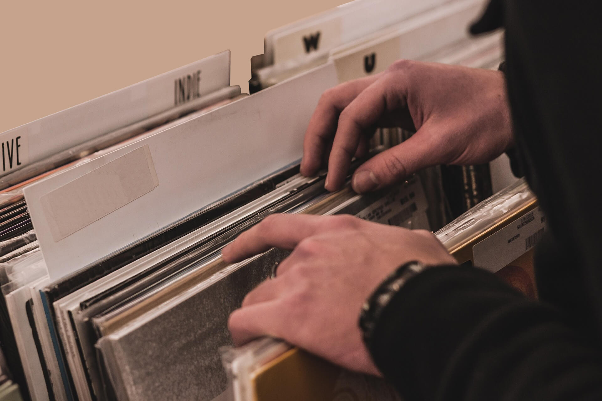 Photo d'un invité à un mariage, qui choisit dans le bar à vinyles, un 33 tours qu'il souhaite que le Dj joue au cocktail